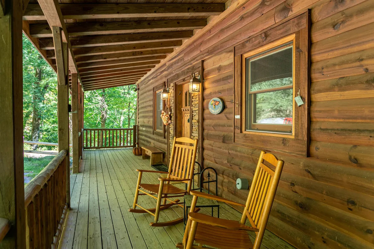 The welcoming front porch features classic rocking chairs, a decorative wreath, and views of the surrounding landscape. It projects warmth and hospitality, illustrating a spot where guests can gather, welcome each other, or simply soak in the natural setting.